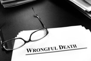 Wrongful death papers on desk with glasses for legal services or lawsuit