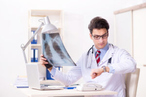 Young handsome doctor working in hospital room