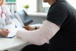 Doctor conducts medical consultation with patient with cast on arm. Hand fracture and treatment